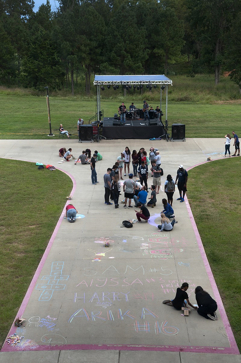 Texas A&M University-Texarkana students 'Chalk the Walk' while listening to the Jason Helms Band on Monday during the opening of Homecoming Week 2016.