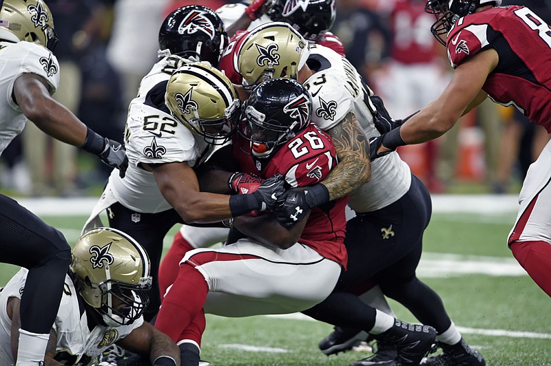 Atlanta Falcons running back Tevin Coleman is stopped by New Orleans Saints linebacker Craig Robertson, left, and linebacker James Laurinaitis on Monday during the first half in New Orleans.
