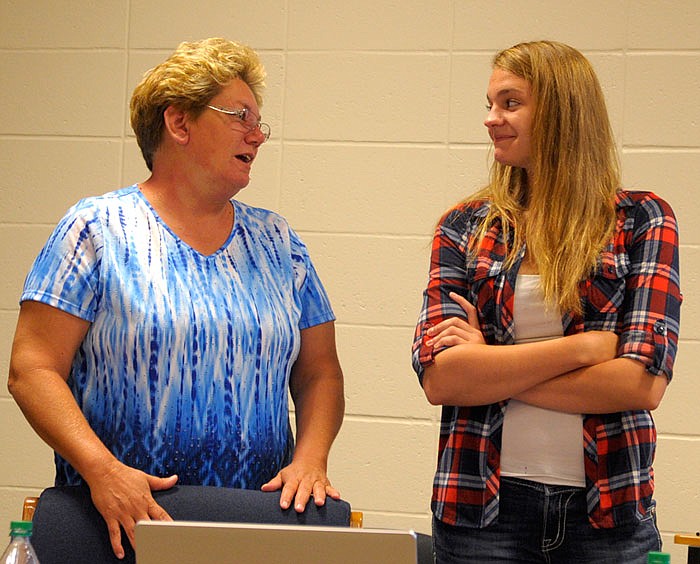 Autumn Fields, right, who received her diploma from California High School at the regular school board meeting Wednesday, discusses her struggles and triumphs with teacher Lorrie Brauner.