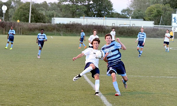 Nick Brandt of Helias and Spencer Hagan of Father Tolton race for the ball during action Monday night at the 179 Soccer Park.