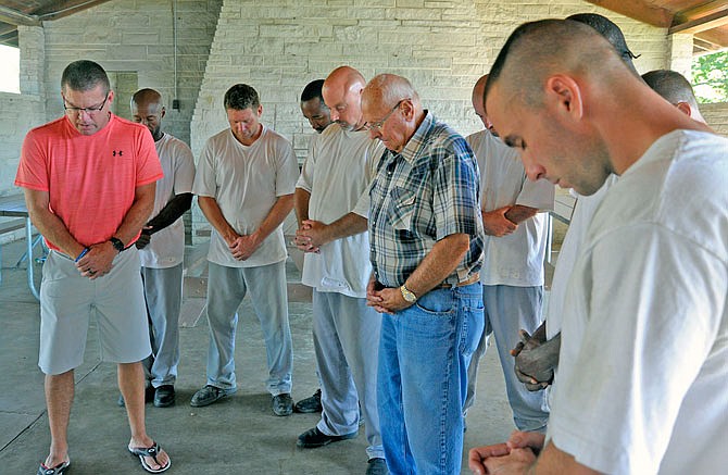 The United Church of Christ and the United Methodist Church have hosted the Inside Church Men's Group for 10 offenders from the Tipton Correctional Center each fall for 17 years. Chairman Mike Staton prays with the offenders and other church volunteers before a meal in late September 2016.