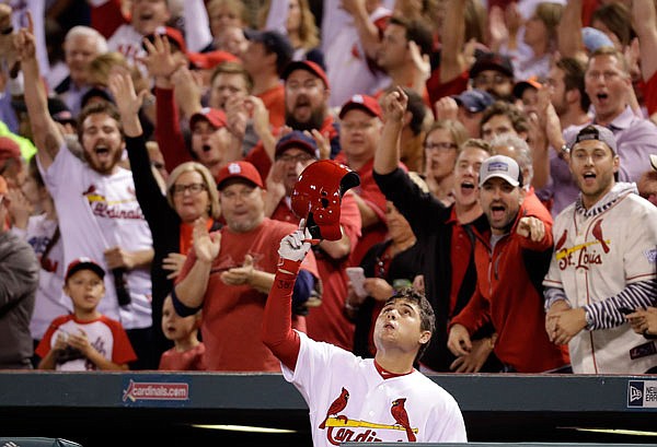 Cardinals shortstop Aledmys Diaz tips his cap and looks skyward after hitting a grand slam during the fourth inning of Tuesday night's game against the Reds in St. Louis. 