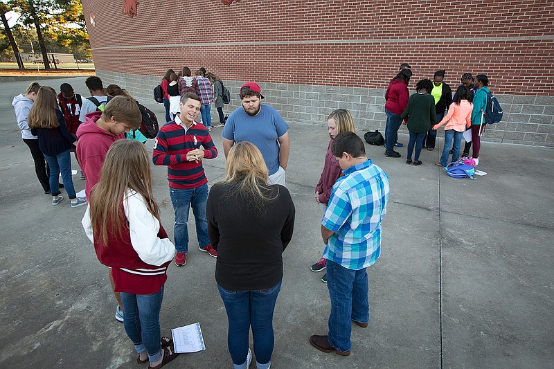 Senior Taylor Sexton leads a small group prayer Wednesday at Arkansas High during See You at the Pole, a student-led public prayer event held nationally. Sexton said he has been involved with the ceremony the past four years. All five local high schools held similar events as well as several area schools. Youth ministers from Church on the Rock, Beech Street Baptist, Anchor Church, City Church and Central Baptist attended.