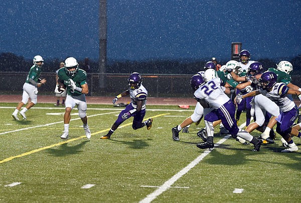 Blair Oaks running back Cody Alexander runs to his right past the Hallsville defensive line for a gain in a game against the Indians earlier this month at the Falcon Athletic Complex in Wardsville.