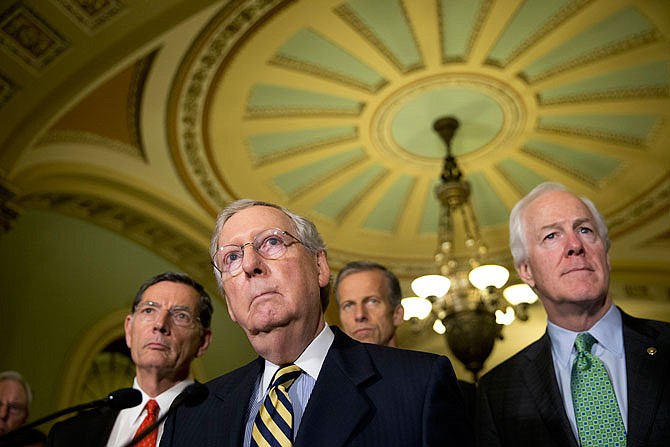 Senate Majority Leader Mitch McConnell of Kentucky, accompanied by, from left, Sen. John Barrasso, R-Wyo., Sen. John Thune, R-S.D., and Senate Majority Whip John Cornyn, of Texas, listen to a question during a June news conference on Capitol Hill in Washington. 