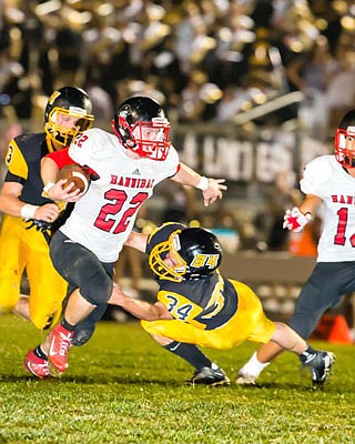 Fulton senior linebacker Brandon Dews tries to grab the leg of Hannibal junior running back Kevin Campbell during the Hornets' 75-22 NCMC home loss to the state-ranked Pirates last Friday night in Fulton.