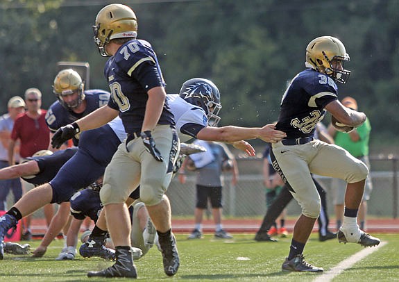 Zach Covington of Helias breaks a tackle attempt on his way to the end zone for a touchdown during last Saturday's game against Father Tolton at Adkins Stadium.