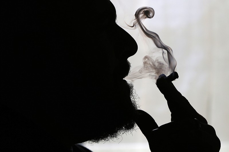 In this Nov. 21, 2014 file photo, former U.S. Marine Sgt. Ryan Begin smokes medical marijuana at his home in Belfast, Maine. From California, with its counterculture heritage, to the fishing ports and mill towns of Maine, millions of Americans in nine states have a chance to vote Nov. 8, 2016, on expanding legal access to marijuana. Collectively, the ballot measures amount to the closest the U.S. has come to a national referendum on the drug. 