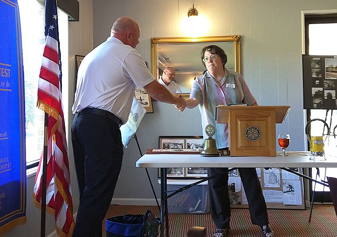 From left, Chris Dickerson, operations manager at the Dollar General distribution center, is sworn into the Fulton Rotary Club by Joan Berry Morris.
