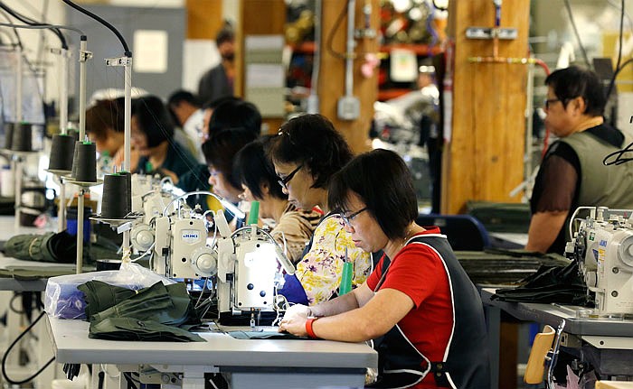 A group of workers at the C.C. Filson Co. manufacturing facility work at their sewing machines, in Seattle. 
