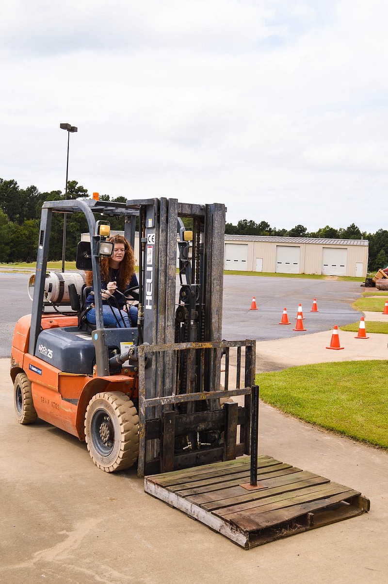 In this undated photo courtesy of University of Arkansas at Hope-Texarkana, Shelly Ross, UAHT Supply Chain Management student, from Nashville, Ark., operates a forklift.