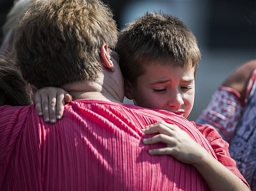 A woman hugs a boy following a shooting at Townville Elementary in Townville Wednesday, Sept. 28, 2016. A teenager killed his father at his home Wednesday before going to the nearby elementary school and opening fire with a handgun, wounding two students and a teacher, authorities said. (Katie McLean/The Independent-Mail via AP)