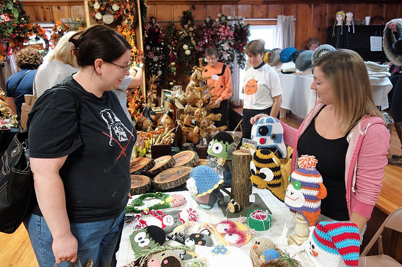 Allie Talley (left) asks Ashley Leakey about her custom crocheted hat made to look like the droid 'R2D2' from 'Star Wars' Saturday, Oct. 1, 2016 at the craft show in Hatton, Mo.
