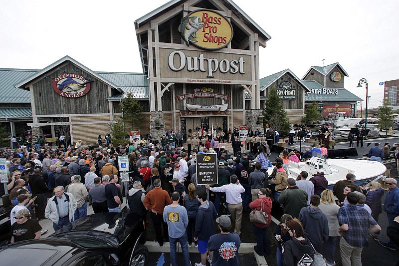 In this Wednesday, April 15, 2015, file photo, a large crowd of people line up as they wait for the grand opening of Bass Pro Shops Outpost store in Atlantic City, N.J. Outdoor gear giants Bass Pro and Cabela's will combine in a $4.5 billion deal announced Monday, Oct. 3, 2016.