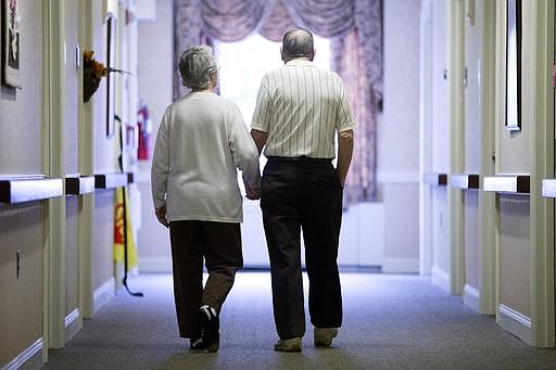 In this Nov. 6, 2015 file photo, an elderly couple walks down a hall in Easton, Pa. It's not too late to get moving: Simple physical activity, mostly walking, helped high-risk seniors stay mobile after disability-inducing ailments even if, at 70 and beyond, they'd long been couch potatoes.