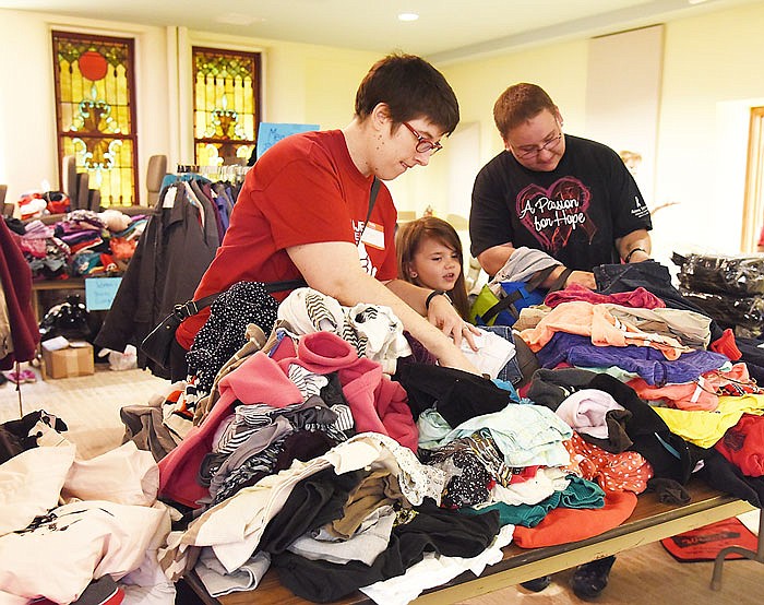 Megan Durham, left, helps Stacie Gleason, at right, looks for clothing for her nieces and nephew at First United Methodist Church (FUMC). In the middle is Trinity Mitts, 6, who was pretty excited to get a new-to-her coat. Durham works in Columbia but took off a few hours to volunteer her time to help out where needed. FUMC was one of three downtown Jefferson City churches to host volunteers and guests at Monday's second Project Homeless Connect, which served as an opportunity for participants to find out information ranged from how to acquire in-state birth certificates to voter registration to employment and housing assistance. The event was also an opportunity to include Lincoln University nursing school students, Cole County Health Department and Community Health medical and dental to serve those who may not otherwise seek out any kind of medical help. In addition to those services, volunteer stylists from Hair Connections cut and styled hair and those in need of a shower, could take a hot shower and get a change of clean clothes. 