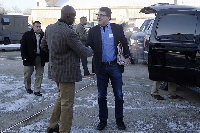 U.S. Secretary of Defense Ash Carter, center, is greeted by Senior Military Assistant U.S. Army Maj. Gen. Ron Lewis last year as they arrive at Andrews Air Force Base, Maryland, to travel to Afghanistan. A Pentagon investigation concluded that Lewis, Carter's former senior military aide, used his government credit card at strip clubs or gentlemen's clubs in Rome and Seoul, drank in excess and had "improper interactions" with women, the Associated Press has learned. 