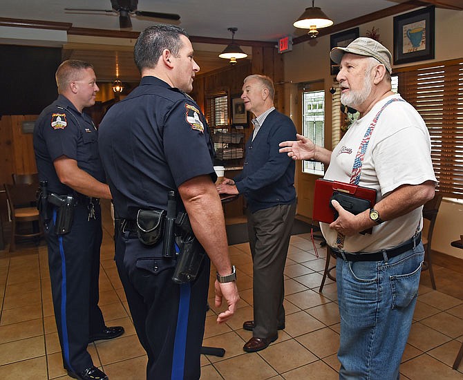 The Jefferson City Police Department hosted Coffee with a Cop Friday morning at Brew House Coffee, 1507 E. McCarty St. Capt. Doug Shoemaker, near left, and Lt. Derrick Heislen, background left, visited with Ed Gray, right, and Clyde Lear and other members of the public about policing issues or any other subjects they cared to bring up.