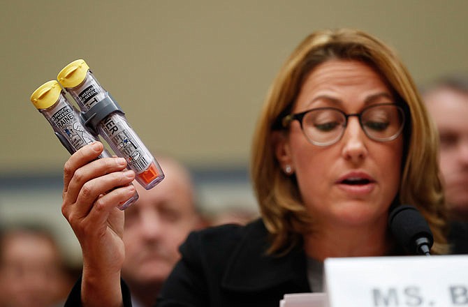 Mylan CEO Heather Bresch holds up EpiPens while testifying on Capitol Hill in September before the House Oversight Committee hearing on EpiPen price increases. Now the federal government, responding to Congressional inquiries, says EpiPen's maker has been overcharging Medicaid for years because the emergency shot is classified incorrectly as a generic medicine.