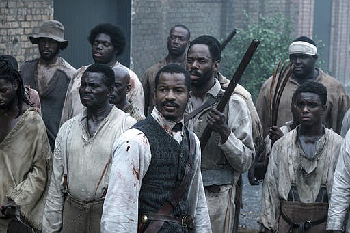 This image released by Fox Searchlight Films shows Nate Parker as Nat Turner, center, in a scene from "The Birth of a Nation."