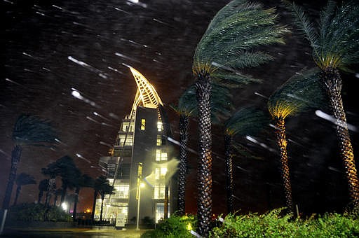Trees sway from heavy rain and wind from Hurricane Matthew in front of Exploration Tower early Friday, Oct. 7, 2016 in Cape Canaveral, Fla. Matthew weakened slightly to a Category 3 storm with maximum sustained winds near 120 mph, but the U.S. National Hurricane Center says it's expected to remain a powerful hurricane as it moves closer to the coast. (Craig Rubadoux/Florida Today via AP)