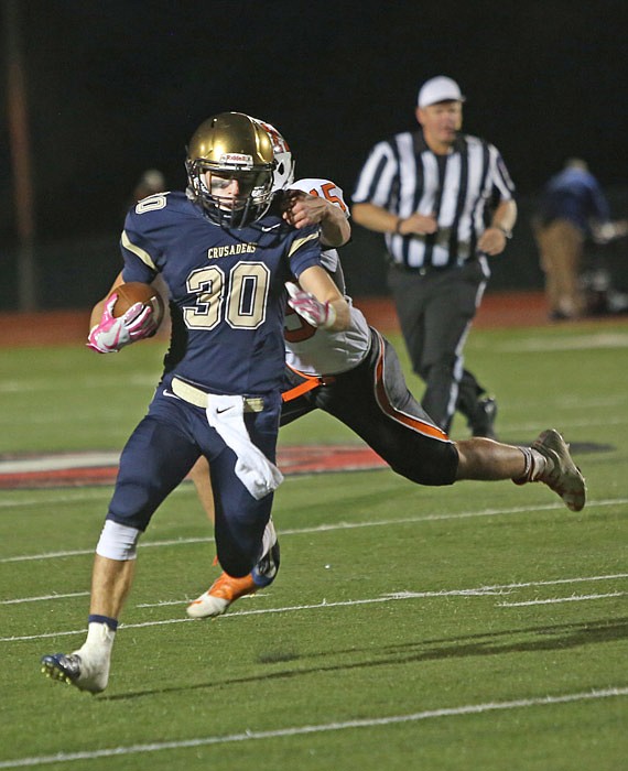 Helias running back Blake Veltrop tries to avoid a tackle from a Kirksville defender Saturday, Oct. 8, 2016, during the game at Adkins Stadium in Jefferson City.