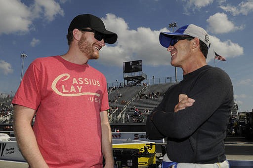 In this photo provided by the NHRA, NASCAR driver Dale Earnhardt Jr., left, talks with NHRA Funny Car driver Ron Capps at the NHRA Carolina Nationals drag races in Concord, N.C., on Friday, Sept. 16, 2016. Earnhardt is sitting out the remainder of the NASCAR season due to concussion-llke systems. 