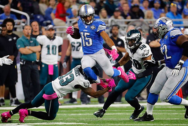 Lions wide receiver Golden Tate (15) leaps past Eagles cornerback Ron Brooks (33) during the first half of Sunday's game in Detroit.