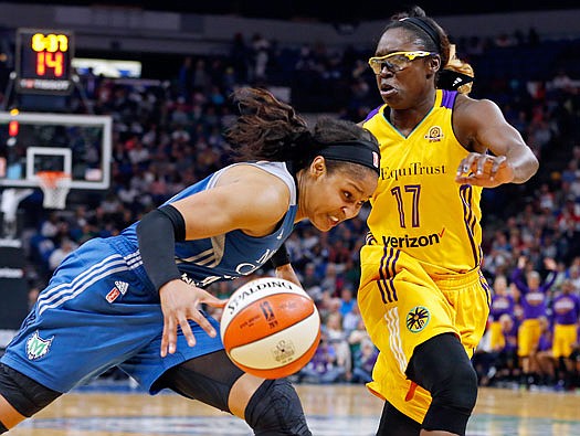 Maya Moore of Minnesota drives around Essence Carson of Los Angeles during in the second half of Tuesday night's game in Minneapolis.