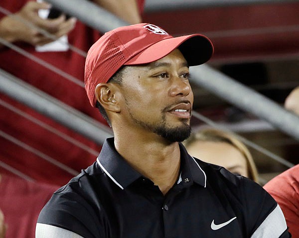 Tiger Woods watches Saturday's college football game between Stanford and Washington State in Stanford, Calif. Woods' comeback is going to have to wait at least two more months. Three days before he was to return at the Safeway Open, Woods said he wasn't ready to return against PGA Tour competition. 