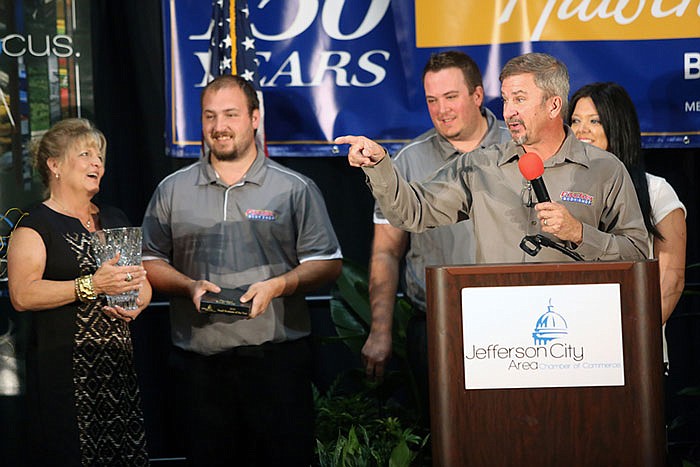 Fischer Body Shop owner Curt Fischer, center, speaks after his business was announced as the winner of the Small Business of the Year award.