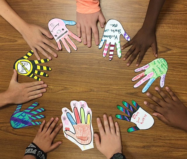 Students at Lewis and Clark Middle School made hand print cut outs with simple ways they can be nice to each other written on them. 