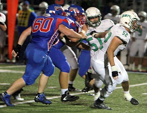 Blair Oaks defensive lineman Mason Gipe (right) surges past the California offensive line to hurry the quarterback during last Friday night's game against the Pintos in California.