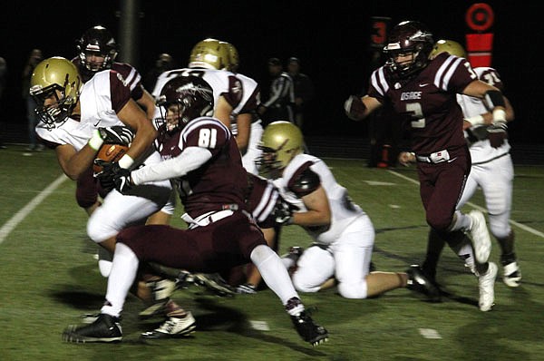 Eldon running back Jordan Metz attempts to pull away from School of the Osage's James McCann during last Friday's game in Osage Beach.