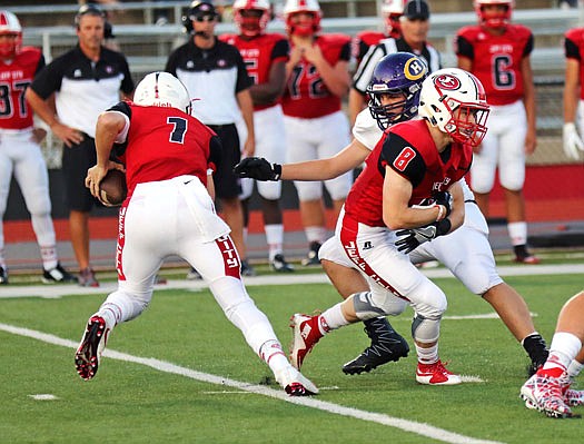 Jefferson City quarterback Gunnar See (left) fakes a handoff to Tyler Bise during a game earlier this season against Hickman at Adkins Stadium. 