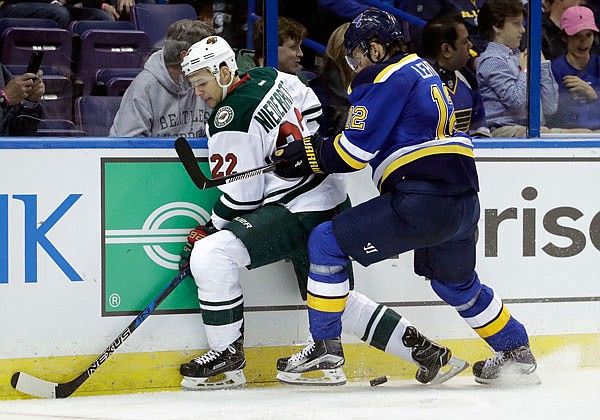 Jori Lehtera of the Blues and Nino Niederreiter of the Wild chase after the puck along the boards during the second period of Thursday's game in St. Louis.