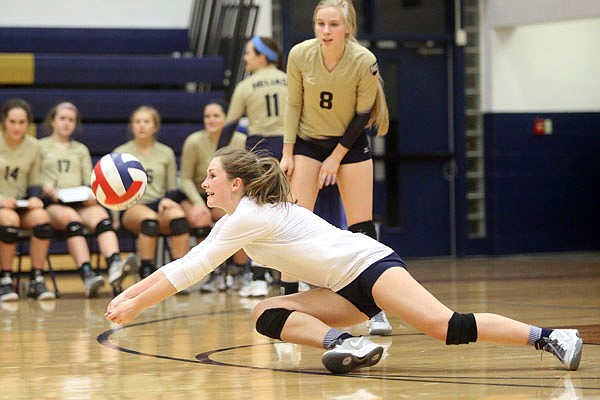 Helias libero Bradi Berhorst dives to the floor for a dig during Thursday's match against Jefferson City at Rackers Fieldhouse.