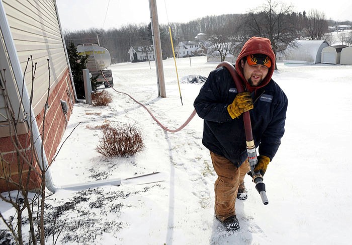 Denver Walker, of Somerset Fuels, makes a heating oil delivery last year to a home in Jenner Crossroads, Pennsulvania. On Thursday, the Energy Department said that household bills from October through March are likely to be higher for all four main heating fuels: natural gas, electricity, heating oil and propane.