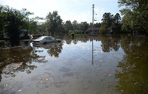 A car in a yard along Cedar Lane, is partially submerged in floodwaters from the rain of Hurricane Matthew, Friday, Oct. 14, 2016, in Kinston, N.C. (Zach Frailey/Daily Free Press via AP)