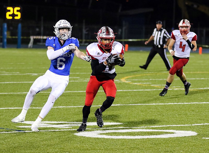 Jefferson City cornerback Dennis Barnes intercepts a pass intended for Rockhurst receiver Chris Teahan and returns it for a touchdown during Friday night's game in Kansas City.