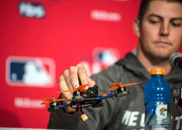 Indians pitcher Trevor Bauer holds a drone which caused a recent injury to his finger during a news conference Sunday in Toronto.