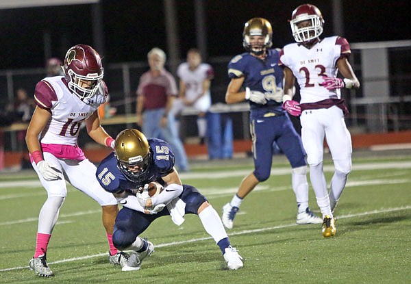 Zach Stiles of Helias makes a fair catch on a punt during Saturday night's game against the DeSmet at Adkins Stadium. Stiles finished with a team-record four interceptions in the game.