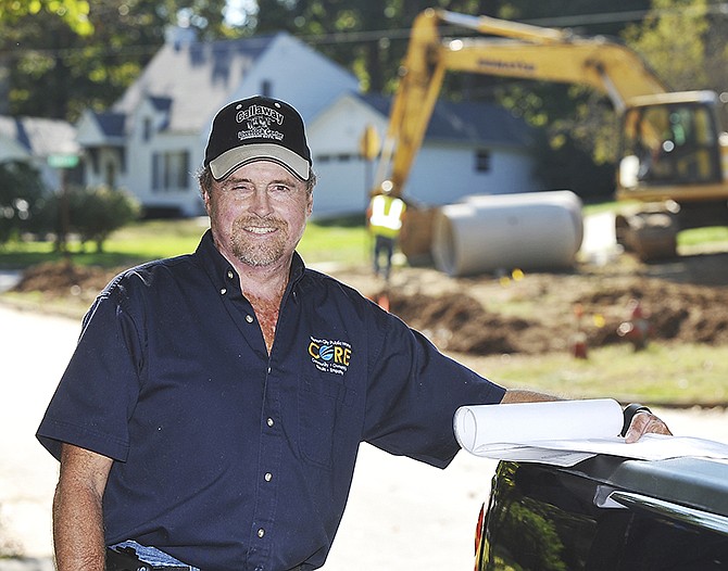 John Voss poses by his city pickup truck while on the jobsite on Forest Hill on the city's west side. Voss, who is a construction inspector, was recently named Jefferson City Employee of the Year. 