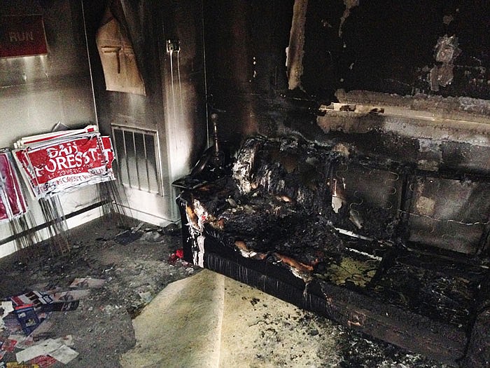 A burned couch is shown next to warped campaign signs at the Orange County Republican Headquarters in Hillsborough, North Carolina on Sunday. Someone threw flammable liquid inside a bottle through a window overnight and someone spray-painted an anti-GOP slogan referring to "Nazi Republicans" on a nearby wall.
