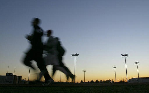 In this Thursday, Jan. 22, 2004 file photo, students jog around a stadium at sunset in Bowling Green, Ky. A large, international study released on Monday, Oct. 10, 2016, ties heavy exertion while stressed or mad to a tripled risk of having a heart attack within an hour. (Clinton Lewis/Daily News via AP)