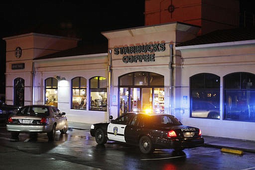 Vallejo Police officers work at the scene of a shooting in Vallejo, Calif., on Sunday, Oct. 16, 2016. Andrew Powell targeted two Northern California police officers who were taking a break at a coffee shop in an ambush that was foiled when his gun malfunctioned, a police chief said Monday. Powell, who was wearing body armor, fled when he could not get his weapon to fire, and the officers gave chase, shooting him three times, authorities said at a news conference. He is in critical but stable condition. (Chris Preovolos/San Francisco Chronicle via AP)