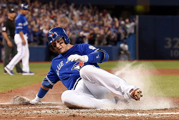 Troy Tulowitzki of the Blue Jays slides across home plate for a run during the fourth inning of Tuesday's game against the Indians in Toronto.