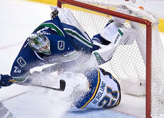 Canucks goalie Jacob Markstrom gets taken out by Blues center Patrik Berglund during the third period of Tuesday night's game in Vancouver, British Columbia.
