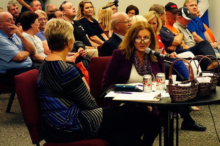 Peg Dzicek, at microphone, moderates a candidate forum Tuesday at Fulton City Hall, sponsored by the Democratic and Republican Committeewomen of Calwood. Sitting with Dzicek is Republican Committeewoman Lori Twillman.