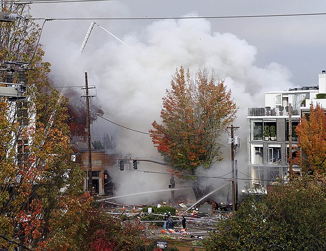 Smoke rises as firefighters battle a blaze Wednesday after a gas explosion in Portland, Oregon. A powerful natural gas explosion neighbors said felt like an earthquake injured two firefighters and two civilians. One building in the popular shopping district was reduced to rubble and the exterior of one side of another building had been ripped off, its windows blown out.